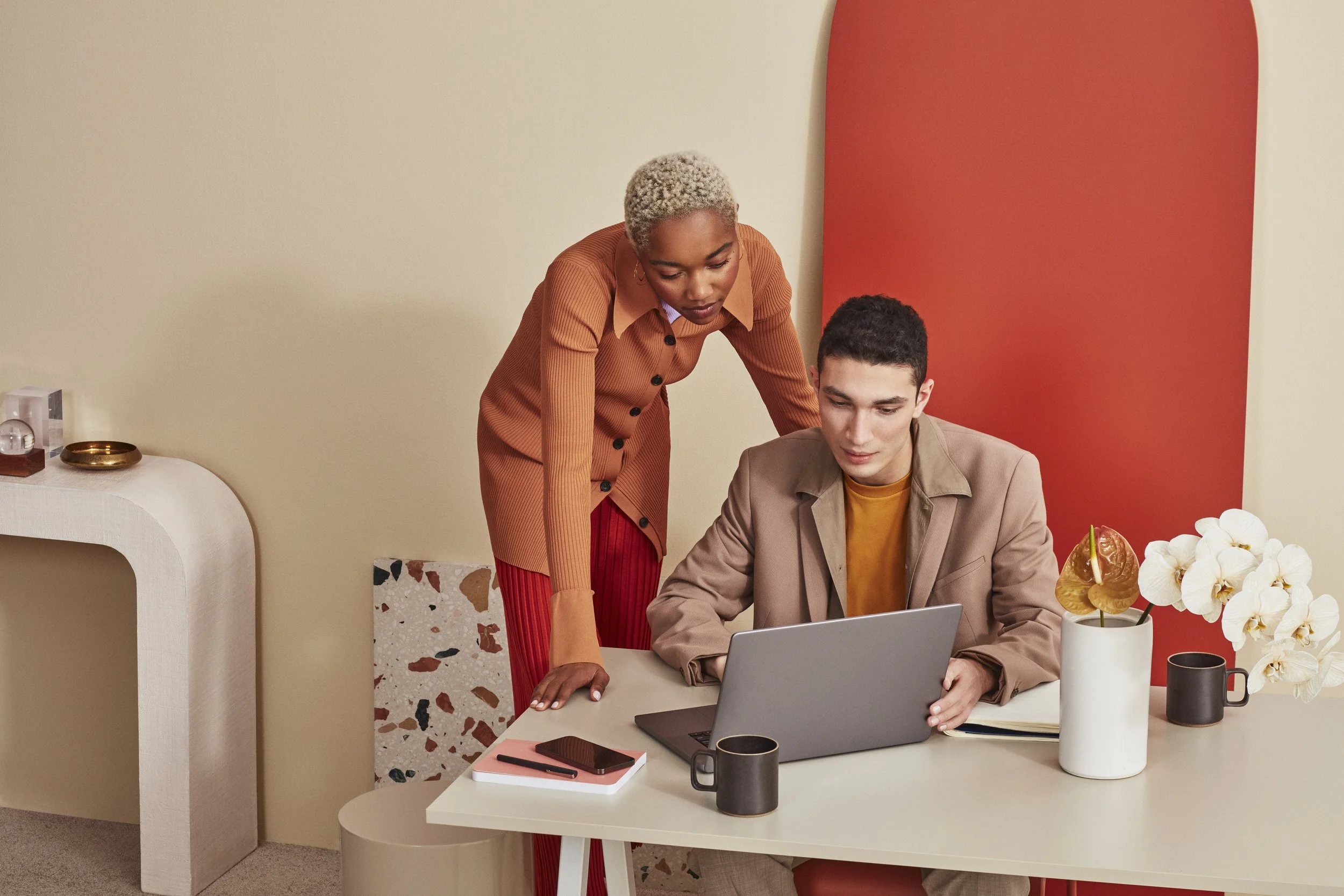 Two creative professionals working together at a laptop